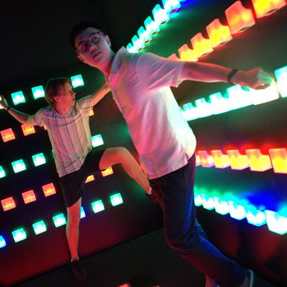 Player balancing between illuminated holds in Power Play Sydney's Climb game room